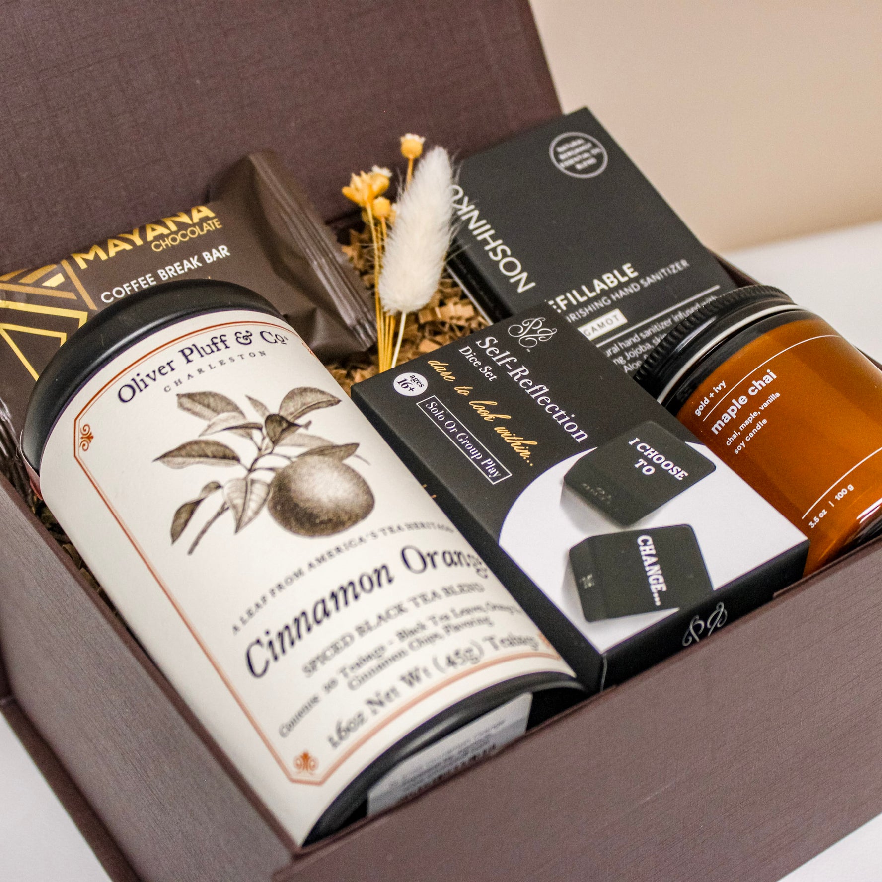 Luxury corporate gift box with tea, candle, chocolate, hand sanitizer and self reflection dice. 